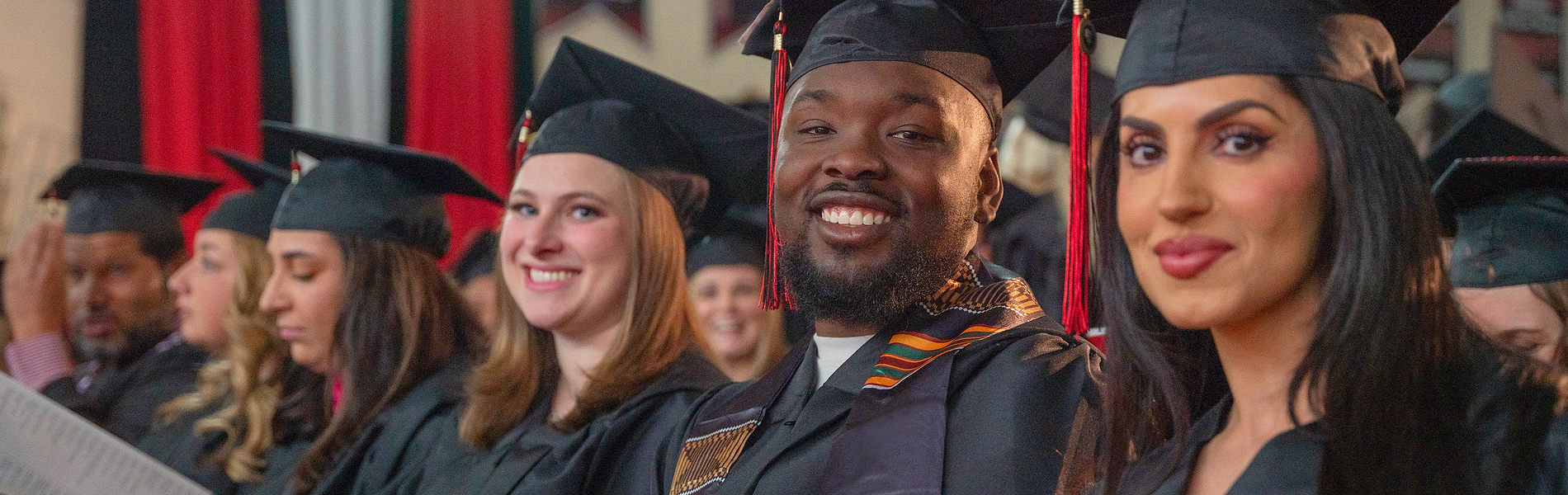 A group of La Roche University graduates seated in rows, wearing traditional commencement caps and gowns.