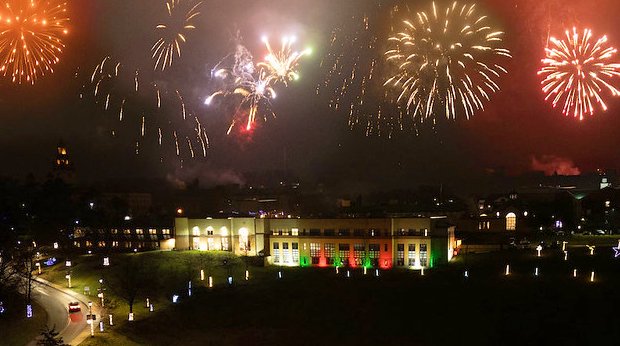 Nighttime view of La Roche University campus lit up with Christmas lights. A display of fireworks is in the sky above the buildings.