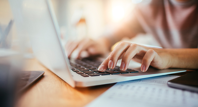 Laptop with hands typing on keyboard