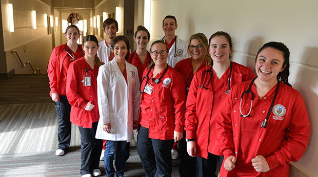 A group of nursing students stand in the hallway of the Zappala Campus Center building.