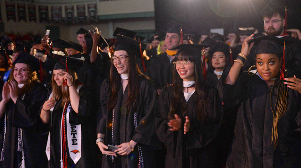 La Roche University graduates wearing their caps and gowns move their tassles and celebrate at a commencement ceremony in the Kerr Fitness & Sports Center.